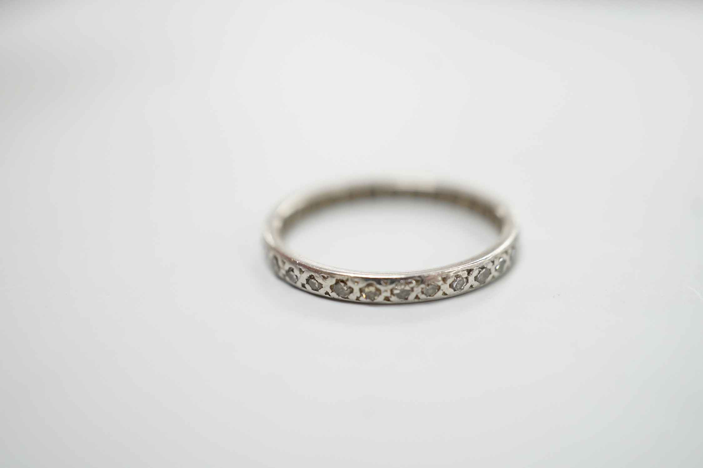 A white metal and diamond chip set full eternity ring, size K, gross weight 1.8 grams.